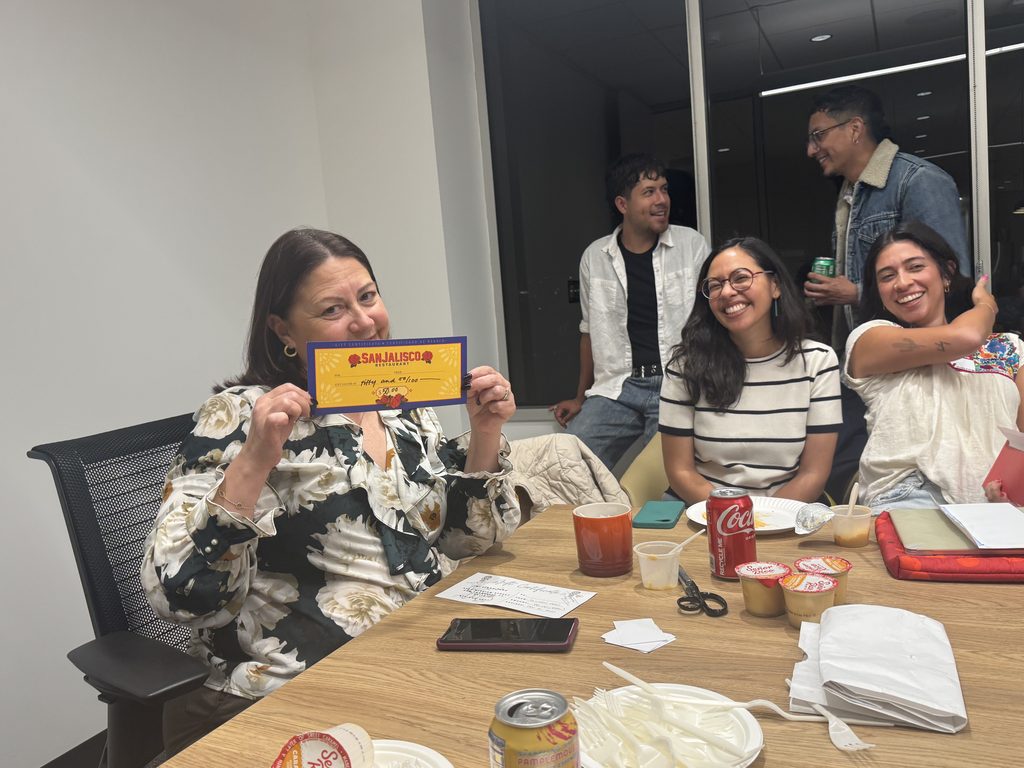 NAHJ Bay Area President Maria Peña holds a gift certificate that was raffled out during the board meeting.